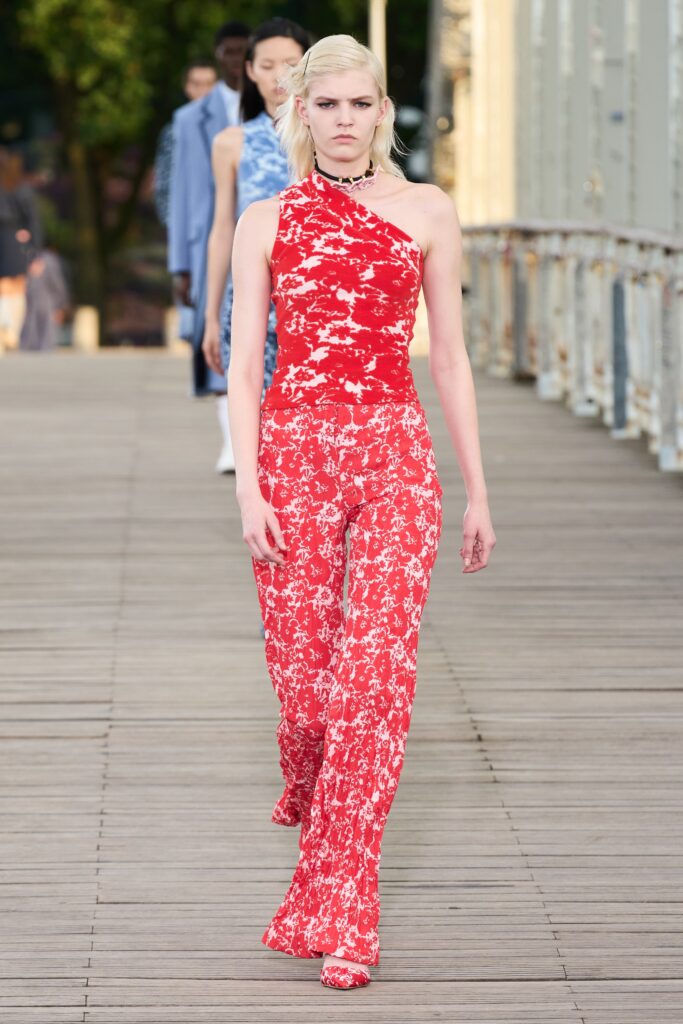 A fitted red floral jumpsuit with a high neckline and flared legs.
