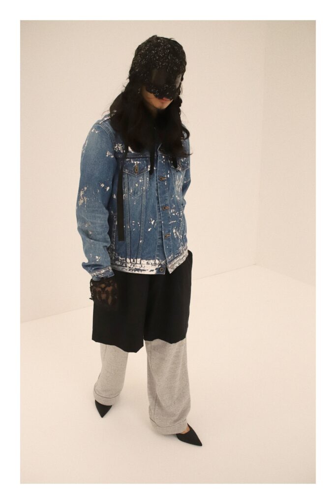 An oversized blue denim jacket paired with fitted gray cotton pants for a stylish look.