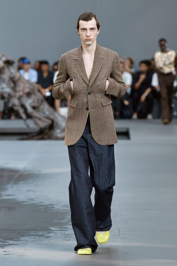 A relaxed brown checked blazer paired with wide-leg blue denim pants.