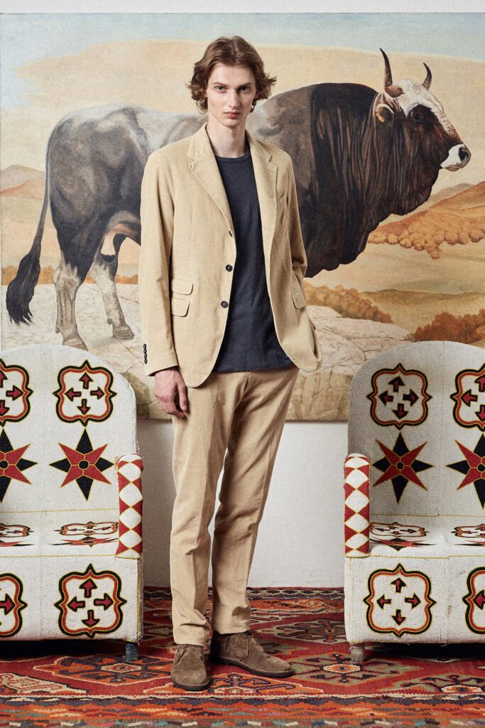 A tailored beige cotton suit with a long-sleeve collared shirt and buttoned details.