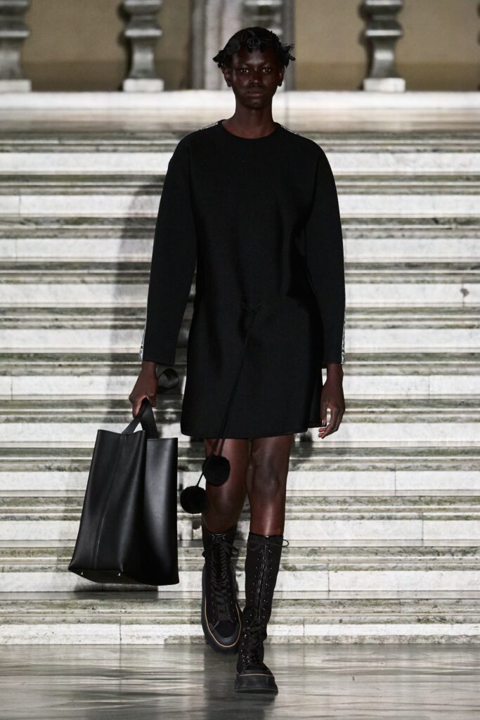 A relaxed black dress with long sleeves and a crew neckline, perfect for casual wear.