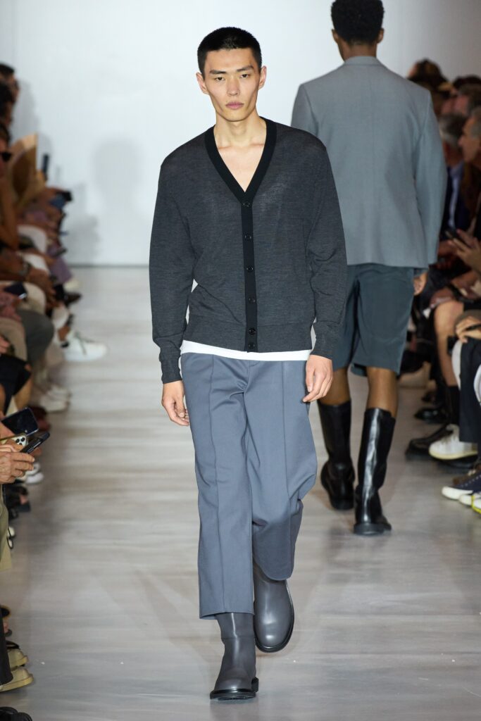 A relaxed gray cardigan with long sleeves paired with straight-leg black pants.