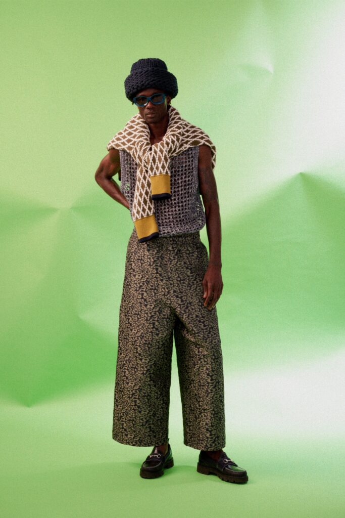 A relaxed black sleeveless top paired with wide-leg printed pants for a stylish look.