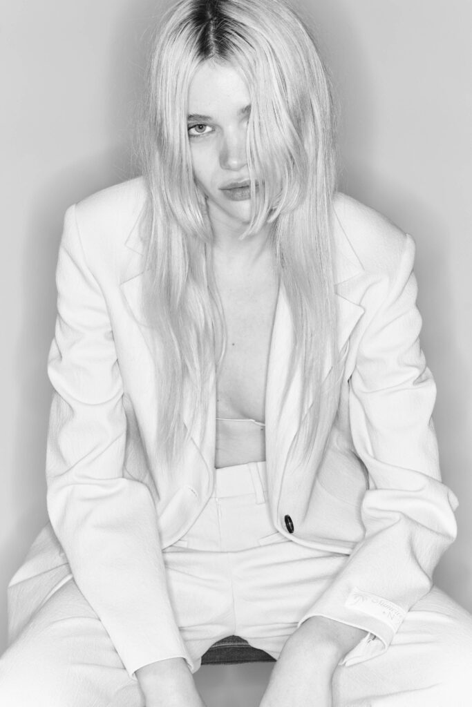 A fitted white cotton suit with long sleeves and a collared design, featuring button details.