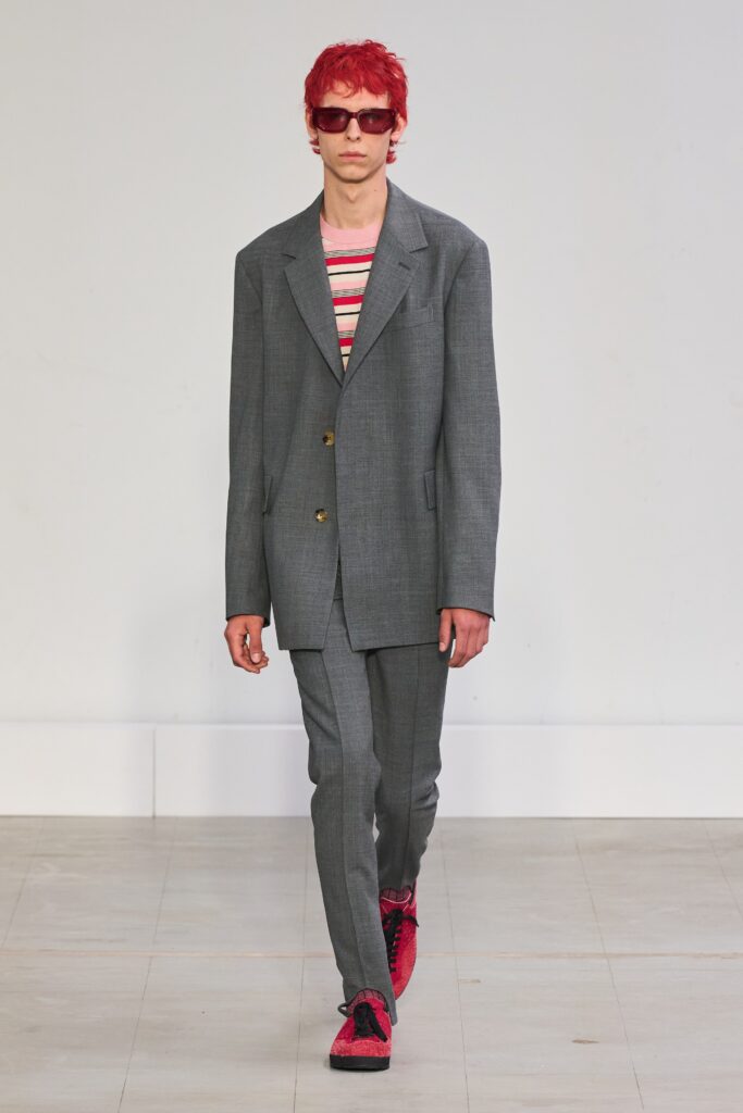A tailored gray suit with long sleeves and a collared design, featuring button details.