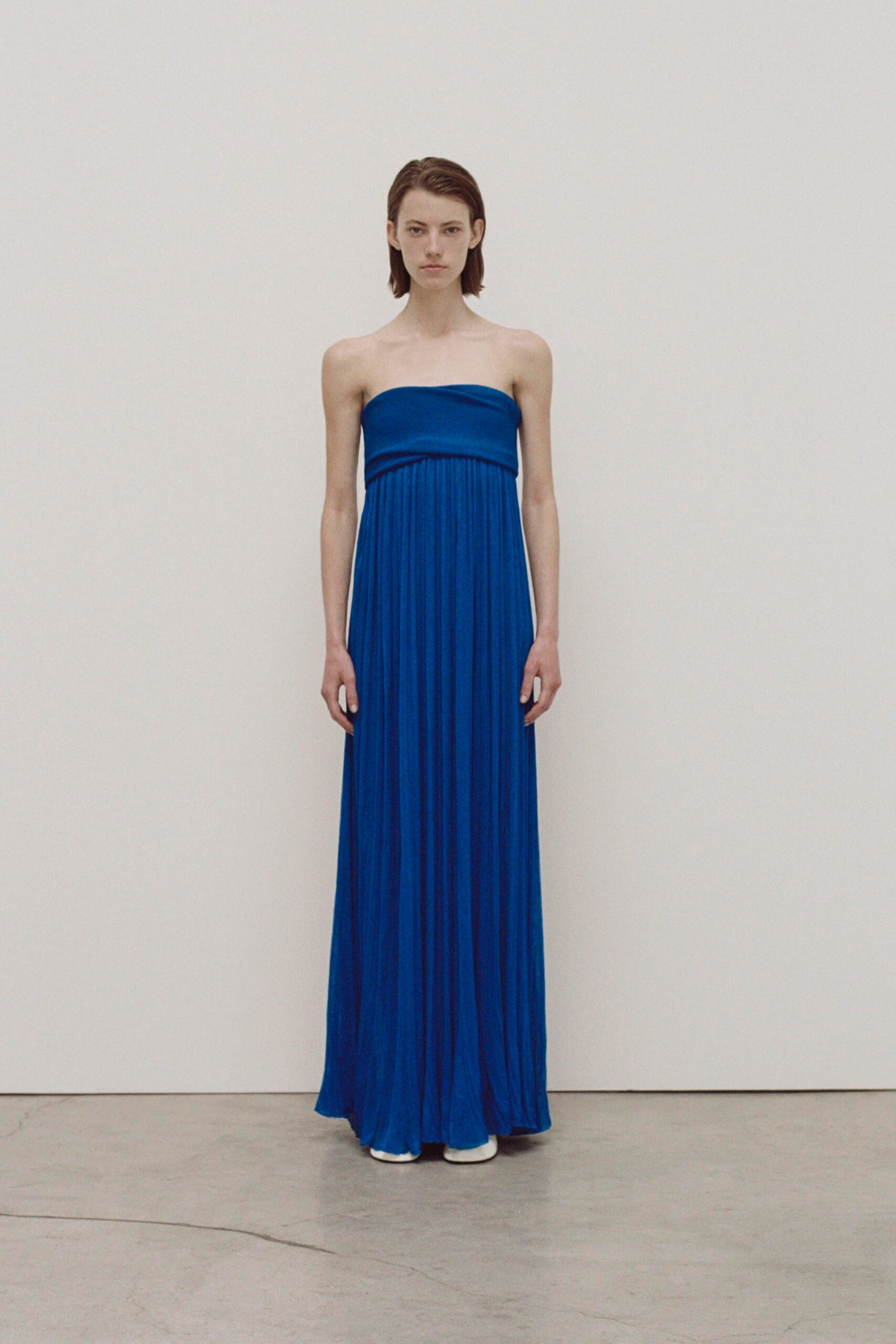 A relaxed blue silk strapless maxi-dress with a draped design.