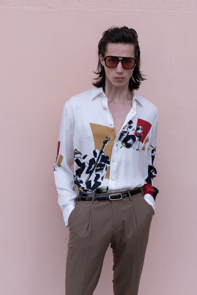 A fitted white printed shirt paired with beige pants, featuring a collared design and long sleeves.