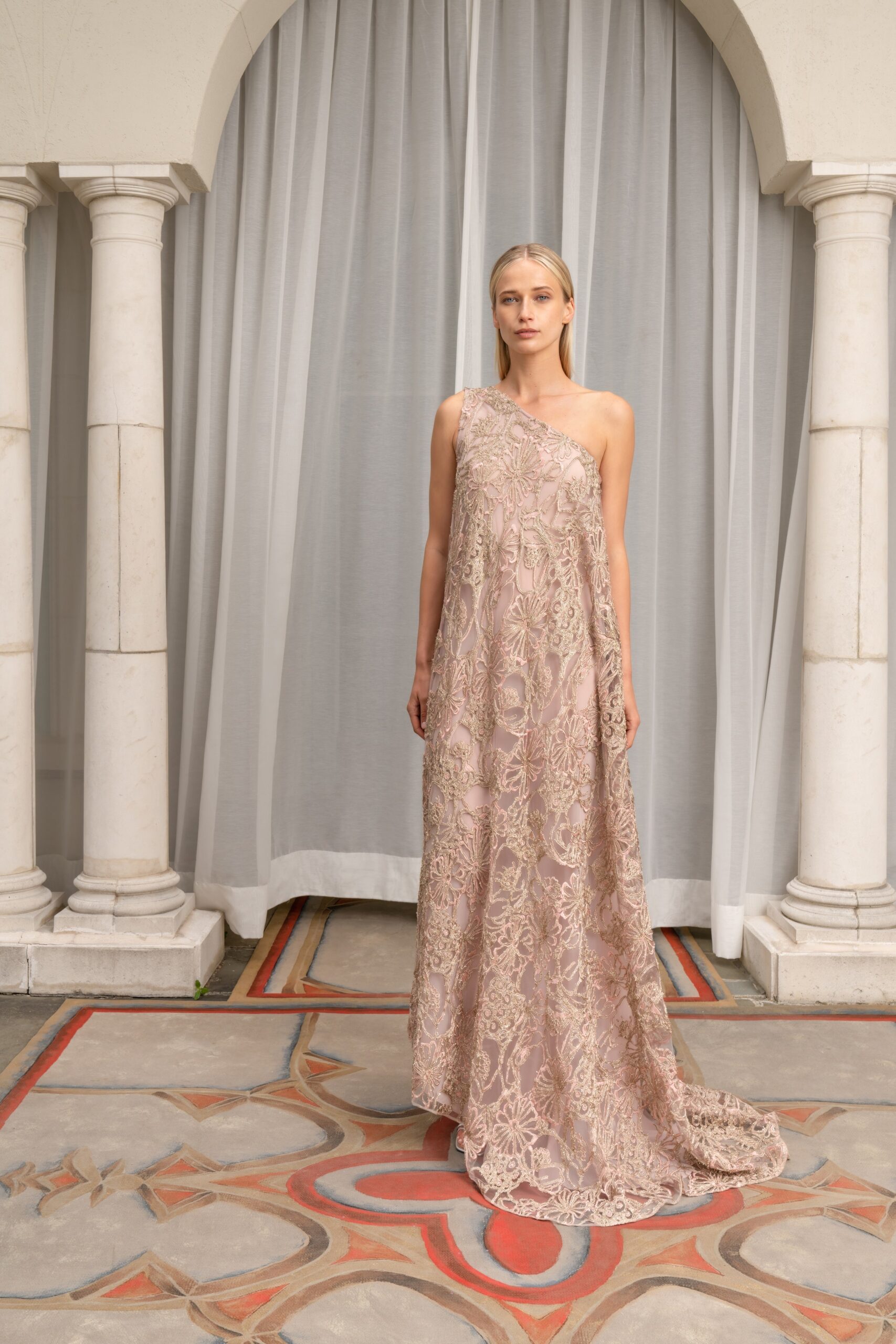 A relaxed beige lace gown with an embroidered design and sleeveless high-neck construction.
