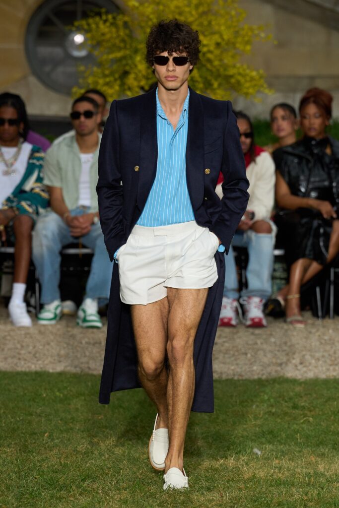 A fitted navy coat over a collared blue shirt, featuring a buttoned design.