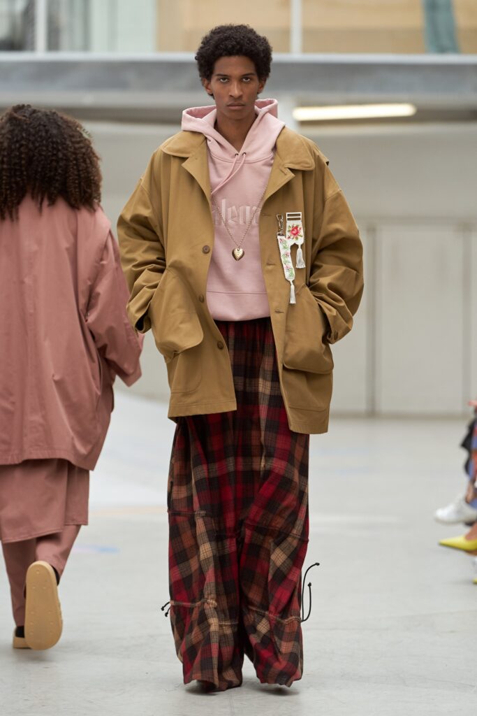 A relaxed brown jacket paired with plaid pants, featuring a hooded design and long sleeves.