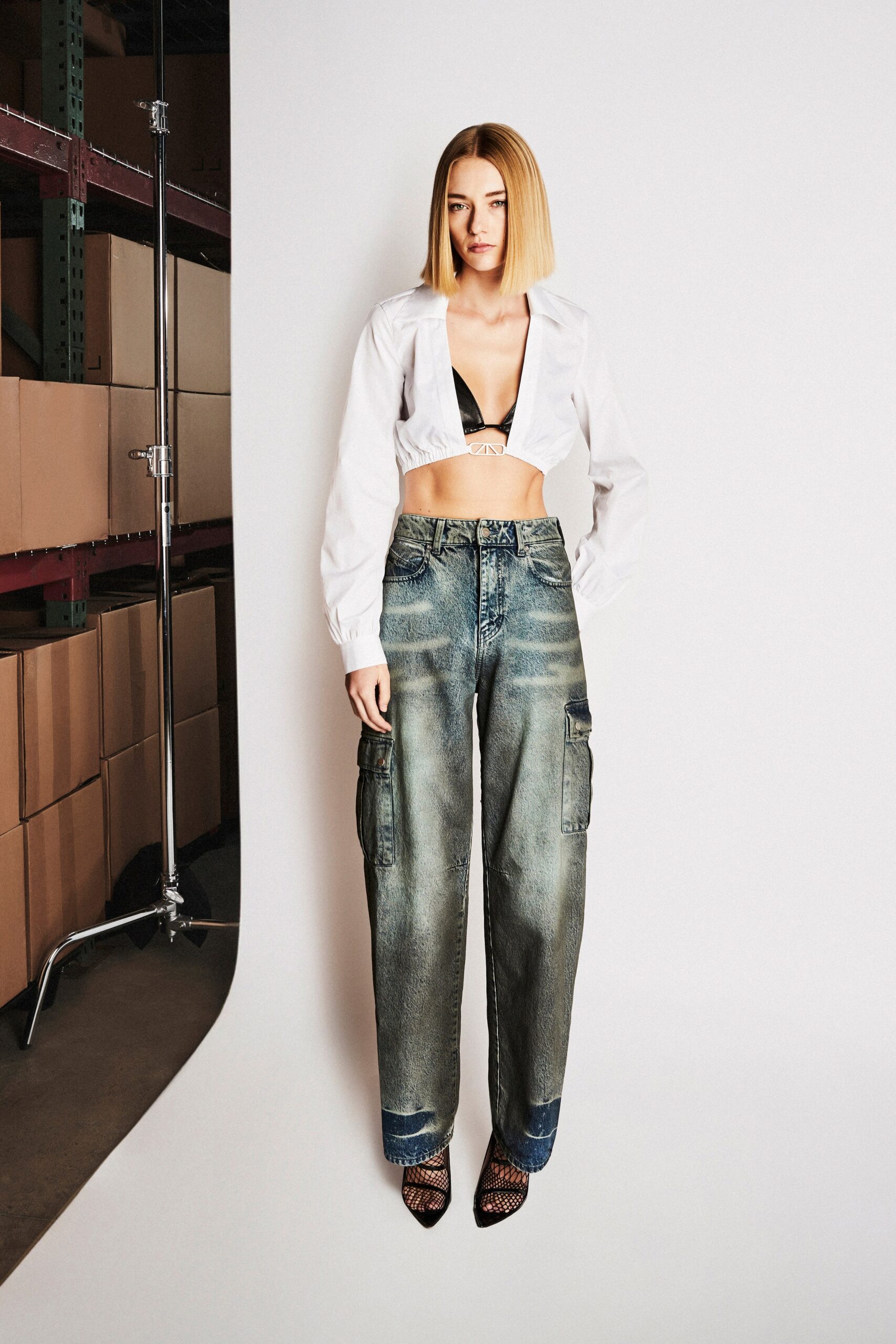 A relaxed white long-sleeve collared cropped shirt paired with relaxed blue wide-leg pants.