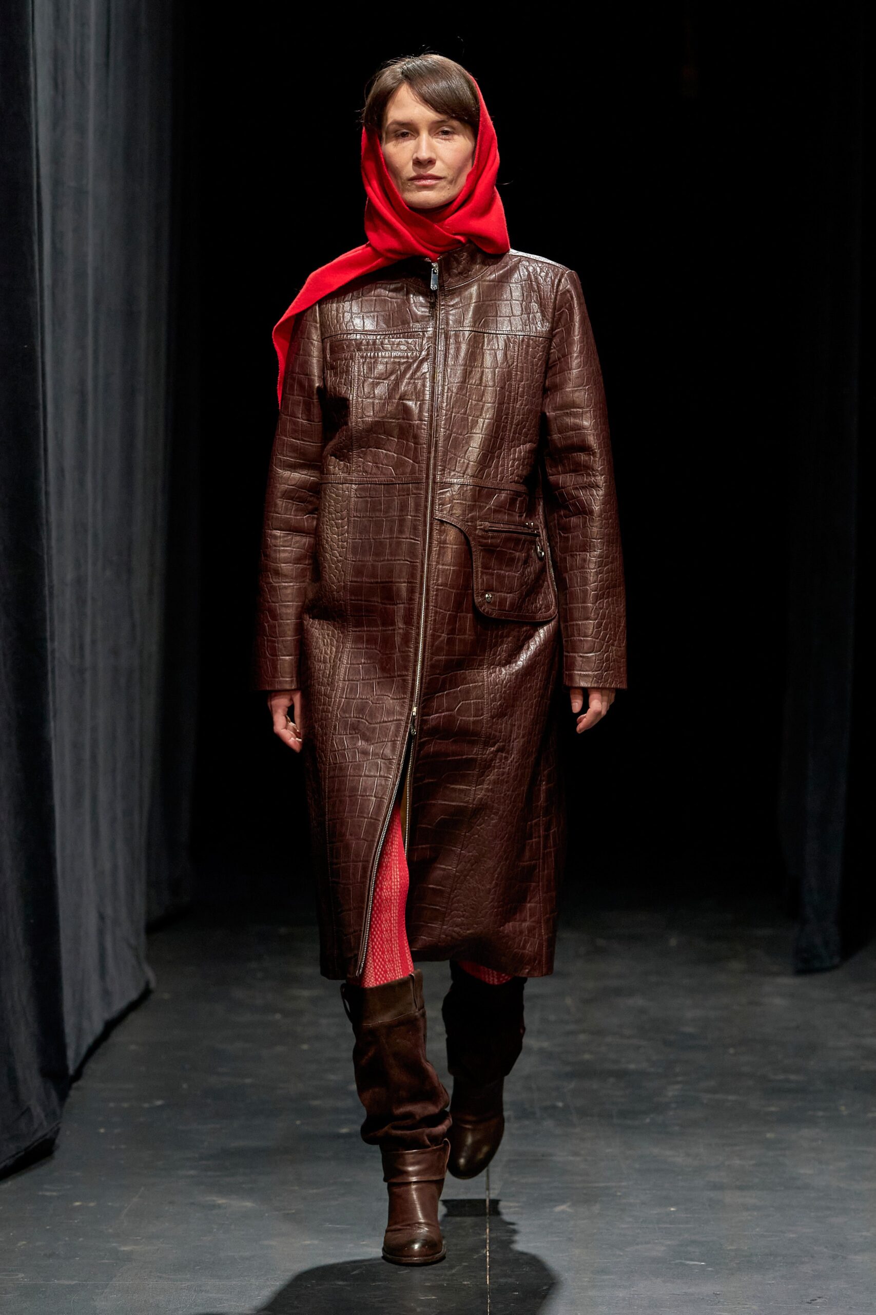 A fitted brown leather coat with a zippered front and long sleeves.