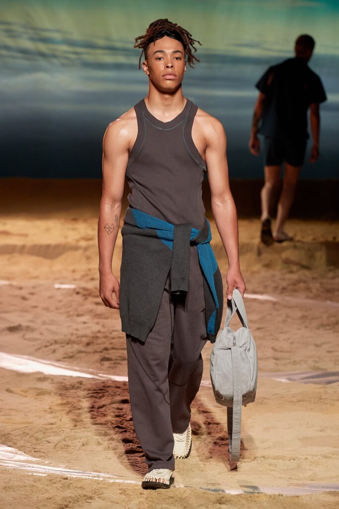 A fitted gray sleeveless tank-top paired with straight-leg pants for a modern look.