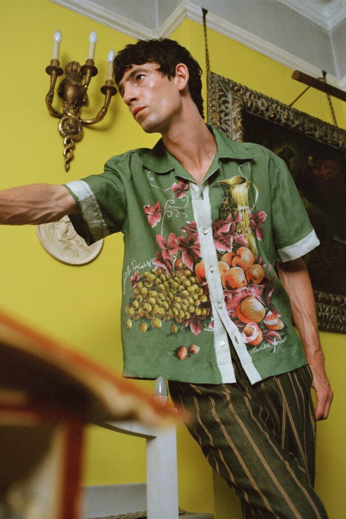 A relaxed green cotton shirt with a collared neckline and vibrant fruit print.