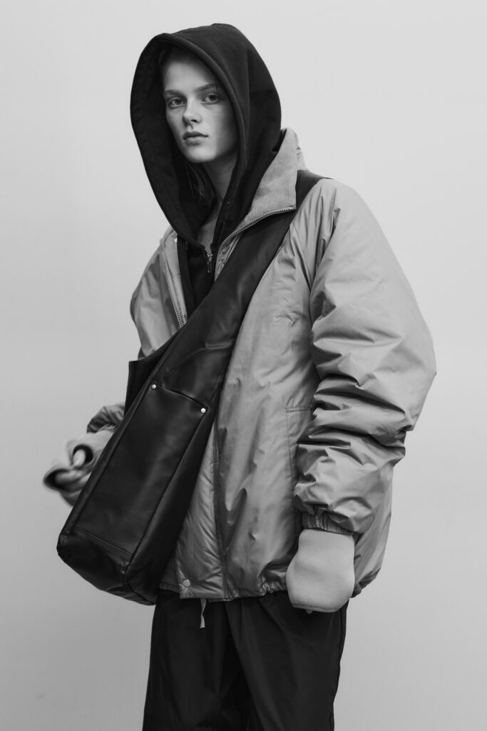 An oversized gray jacket layered over a black hoodie, featuring long sleeves and a relaxed fit.