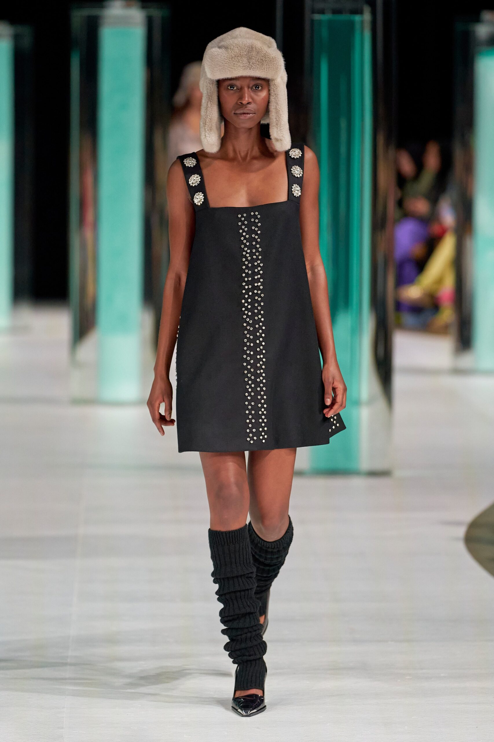 A fitted black sleeveless dress with a square neckline and embroidered details.