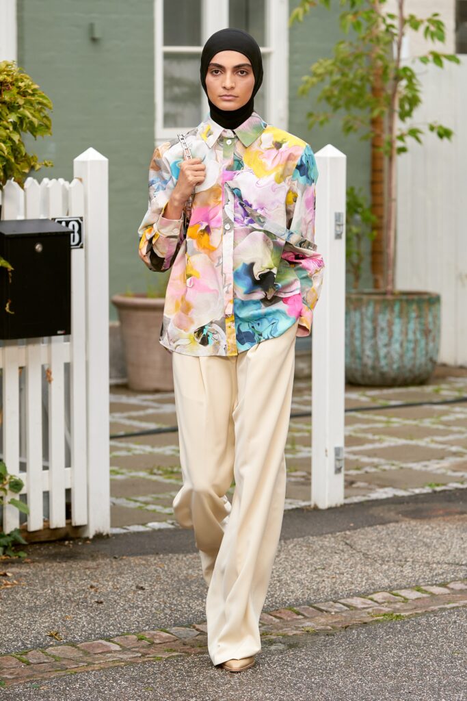 A relaxed-fit multicolor shirt with long sleeves and collared design paired with beige pants.
