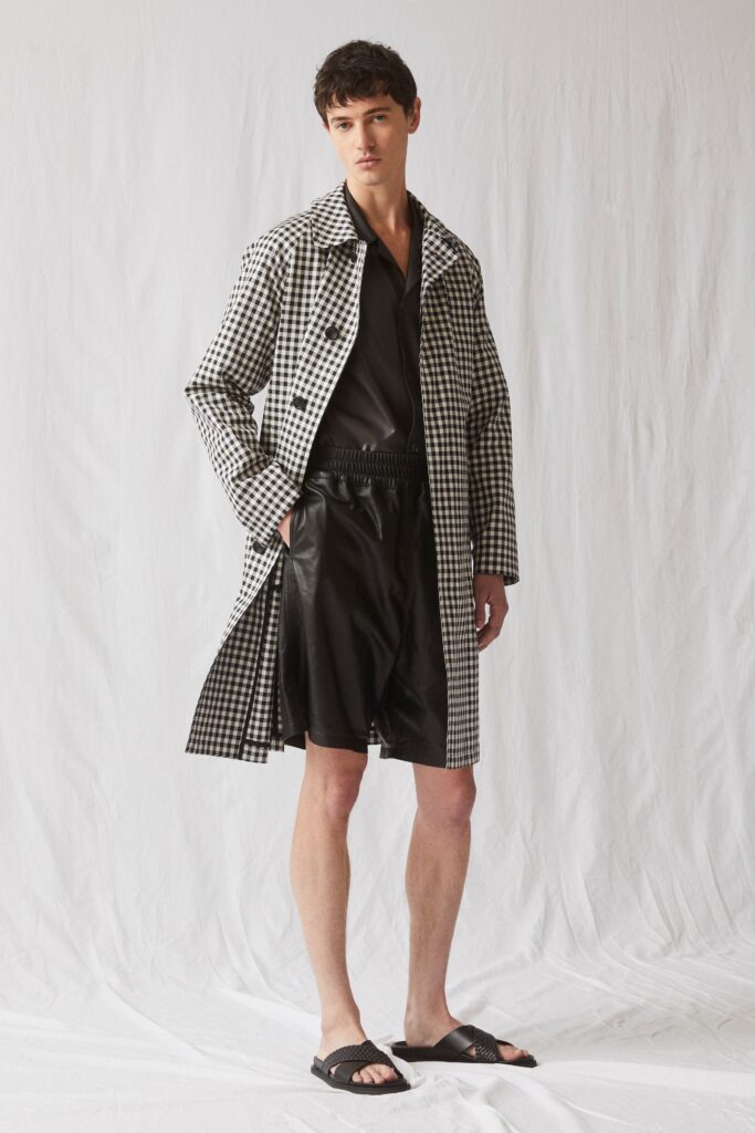 A relaxed fit checked coat paired with black leather shorts for a modern look.