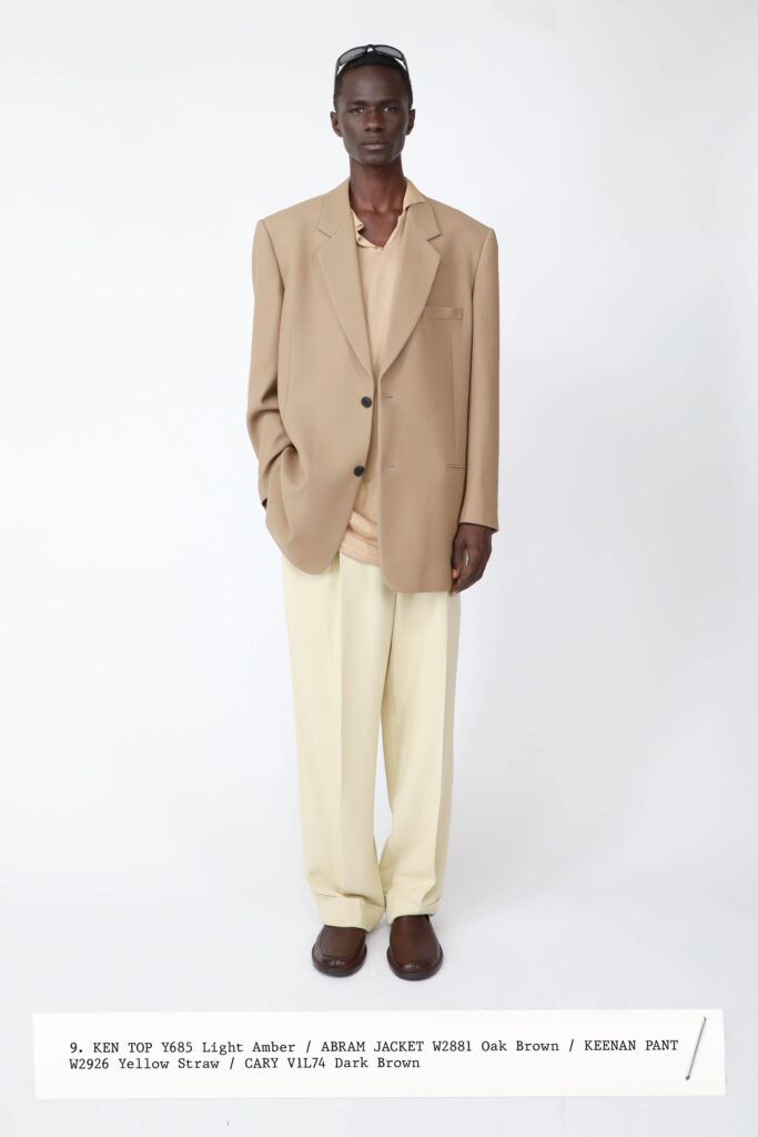 A relaxed beige cotton jacket with long sleeves paired with wide-leg yellow pants.