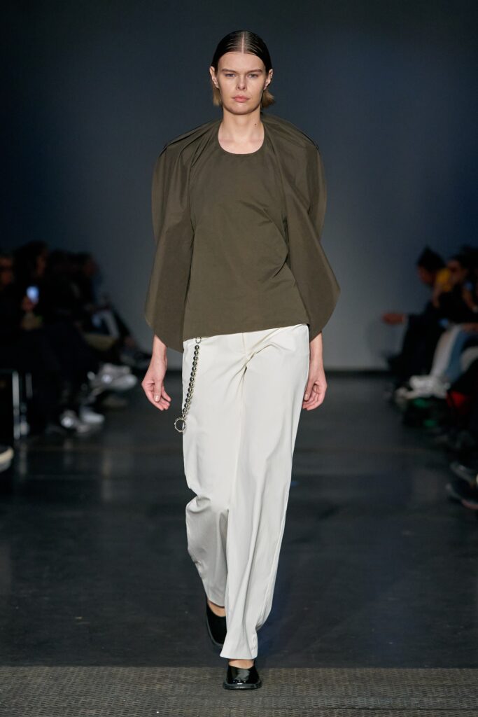 A relaxed green cotton short-sleeve top paired with straight-leg white pants.