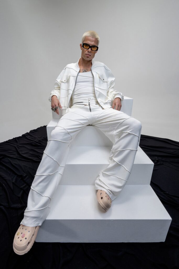 A fitted white cotton jacket with long sleeves and collared design paired with straight-leg pants.