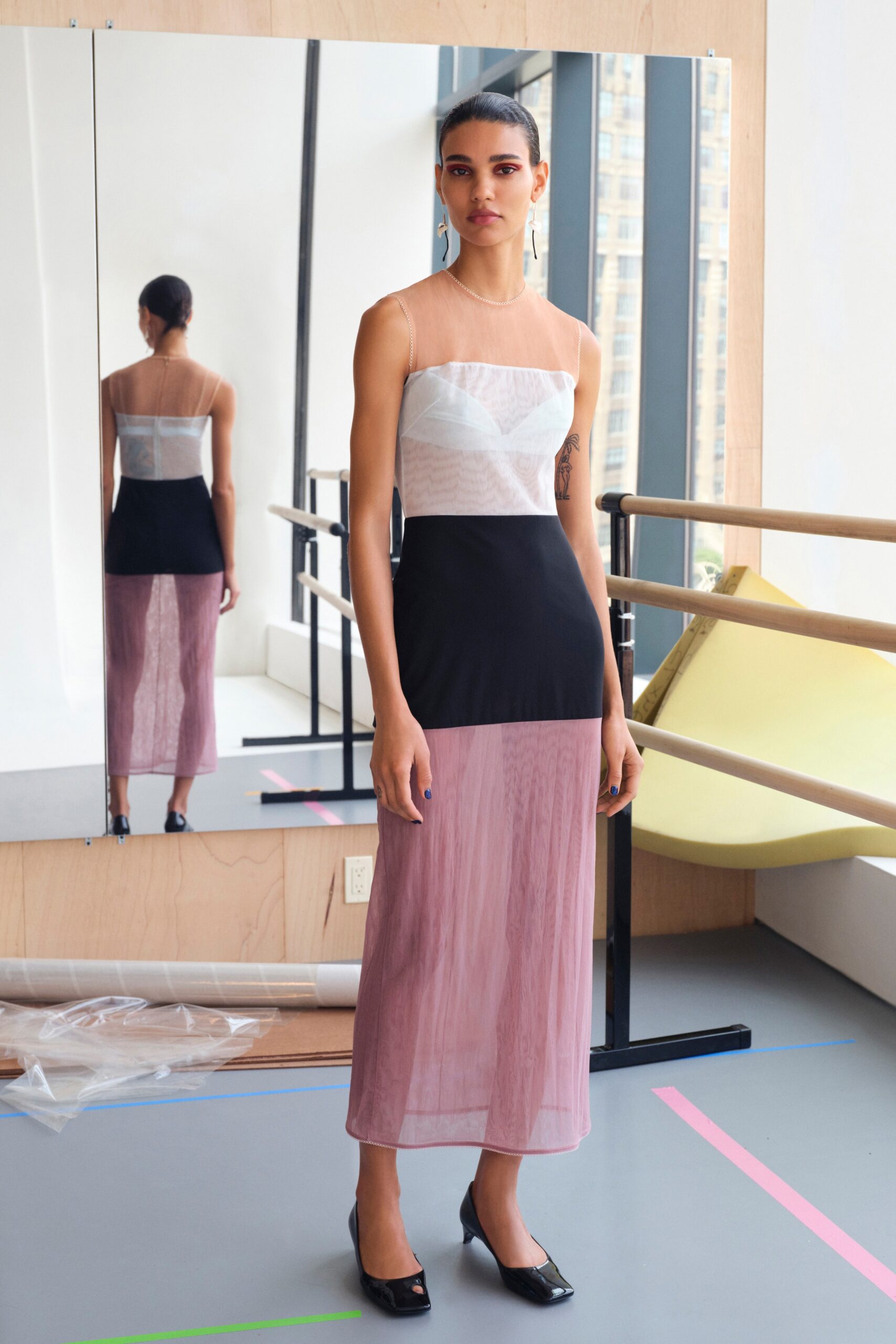A fitted color-blocked dress featuring a sleeveless design and V-neckline.