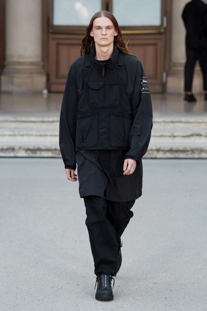 A relaxed black jacket with long sleeves paired with matching black pants featuring zippered details.