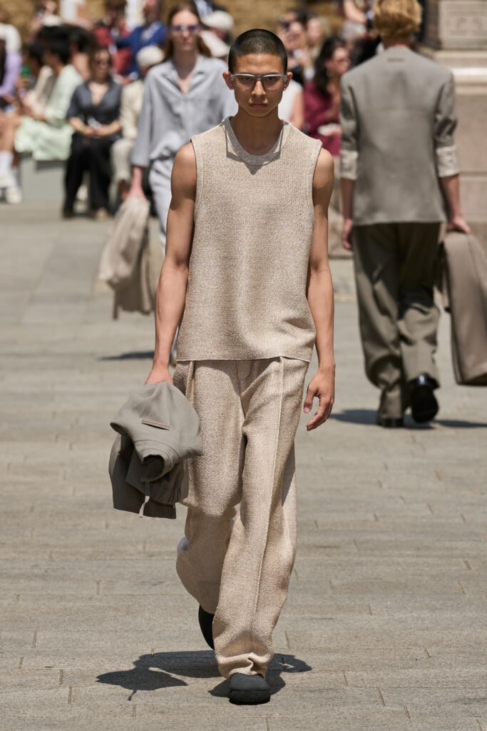 A relaxed beige sleeveless top paired with straight-leg pants for a casual yet stylish look.