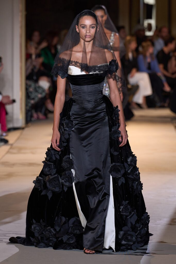 A fitted black and white off-shoulder gown with layered flared details.