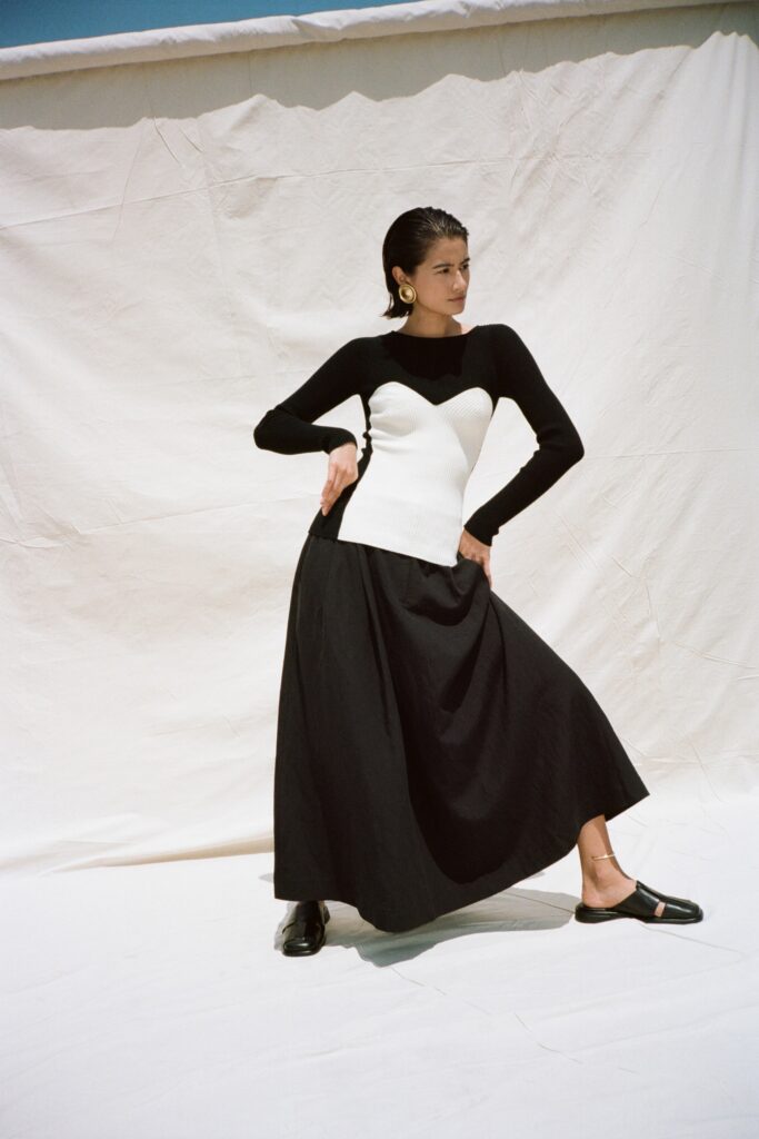 A fitted black and white dress with long sleeves and a high neckline in an A-line silhouette.