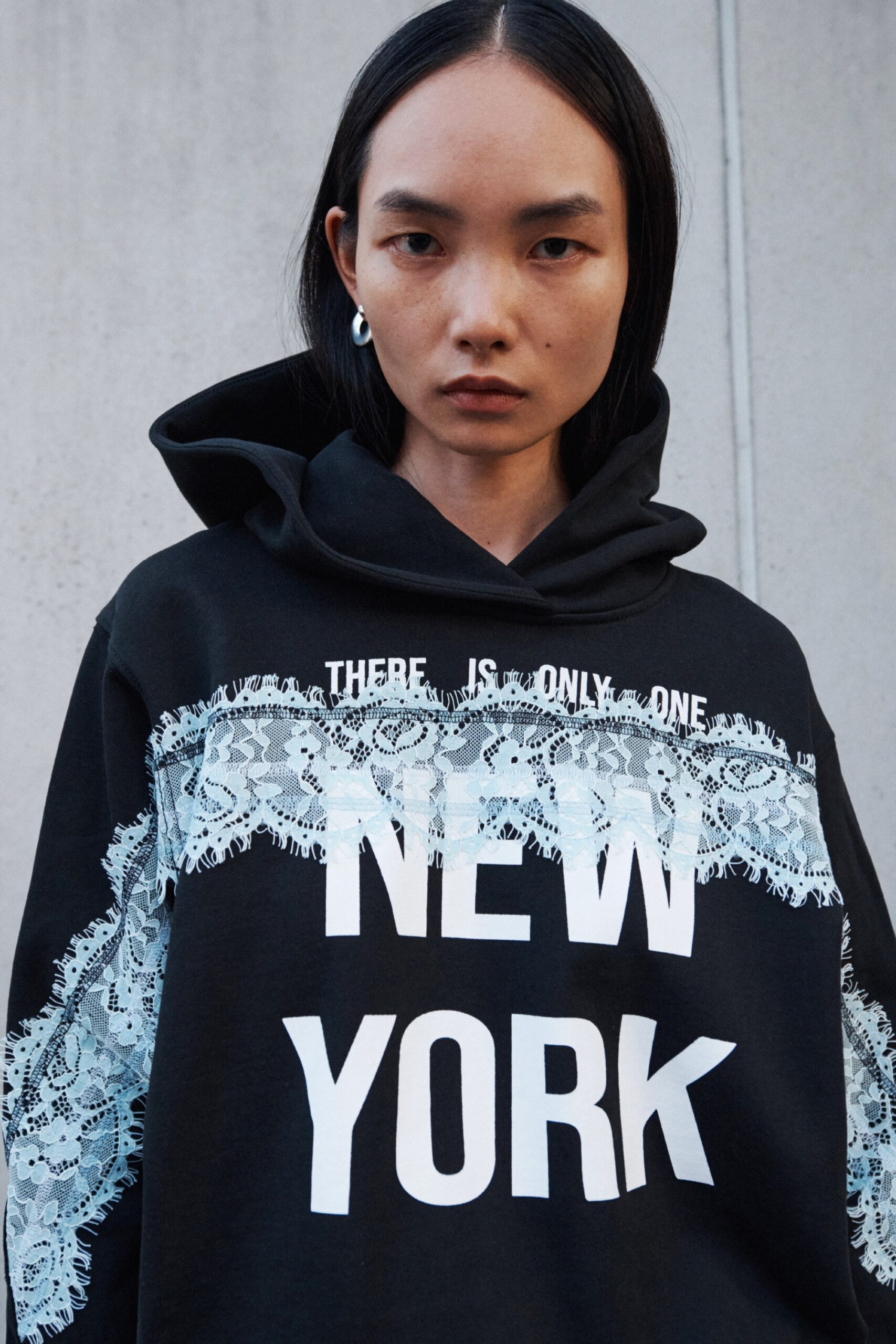 A relaxed black hoodie with long sleeves and a printed design featuring 'NEW YORK'.