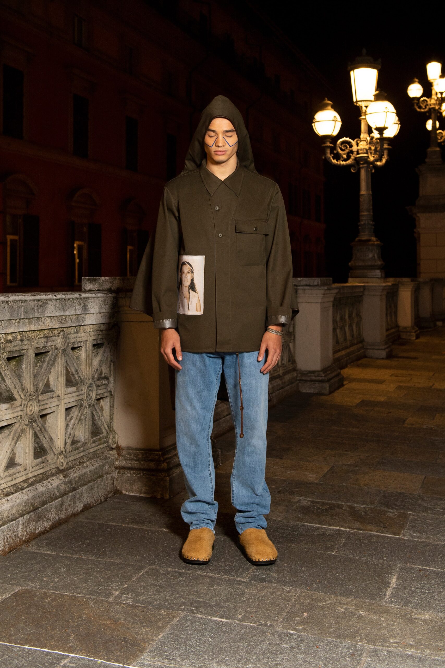 A relaxed-fit green jacket with long sleeves paired with straight-leg blue denim pants.