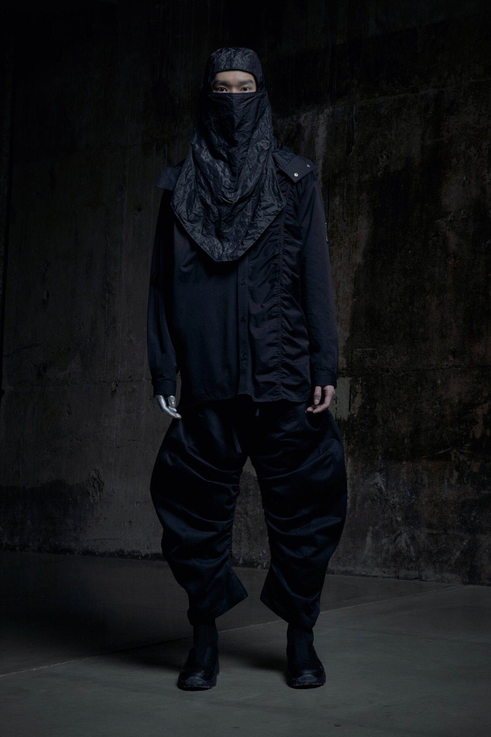 A relaxed black long-sleeve shirt with a collared design and asymmetric pants.