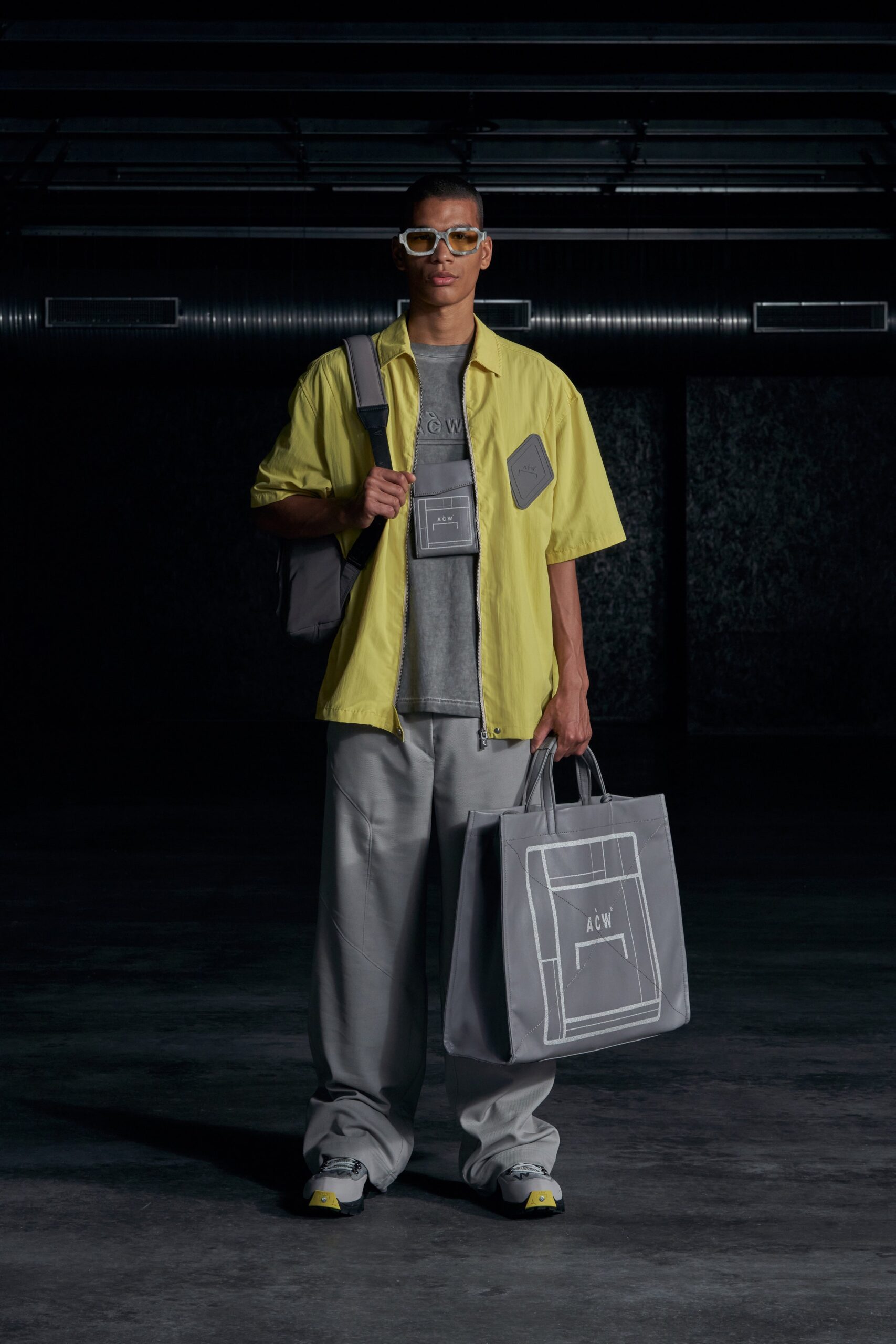 A relaxed-fit yellow short-sleeve collared shirt paired with gray relaxed pants.