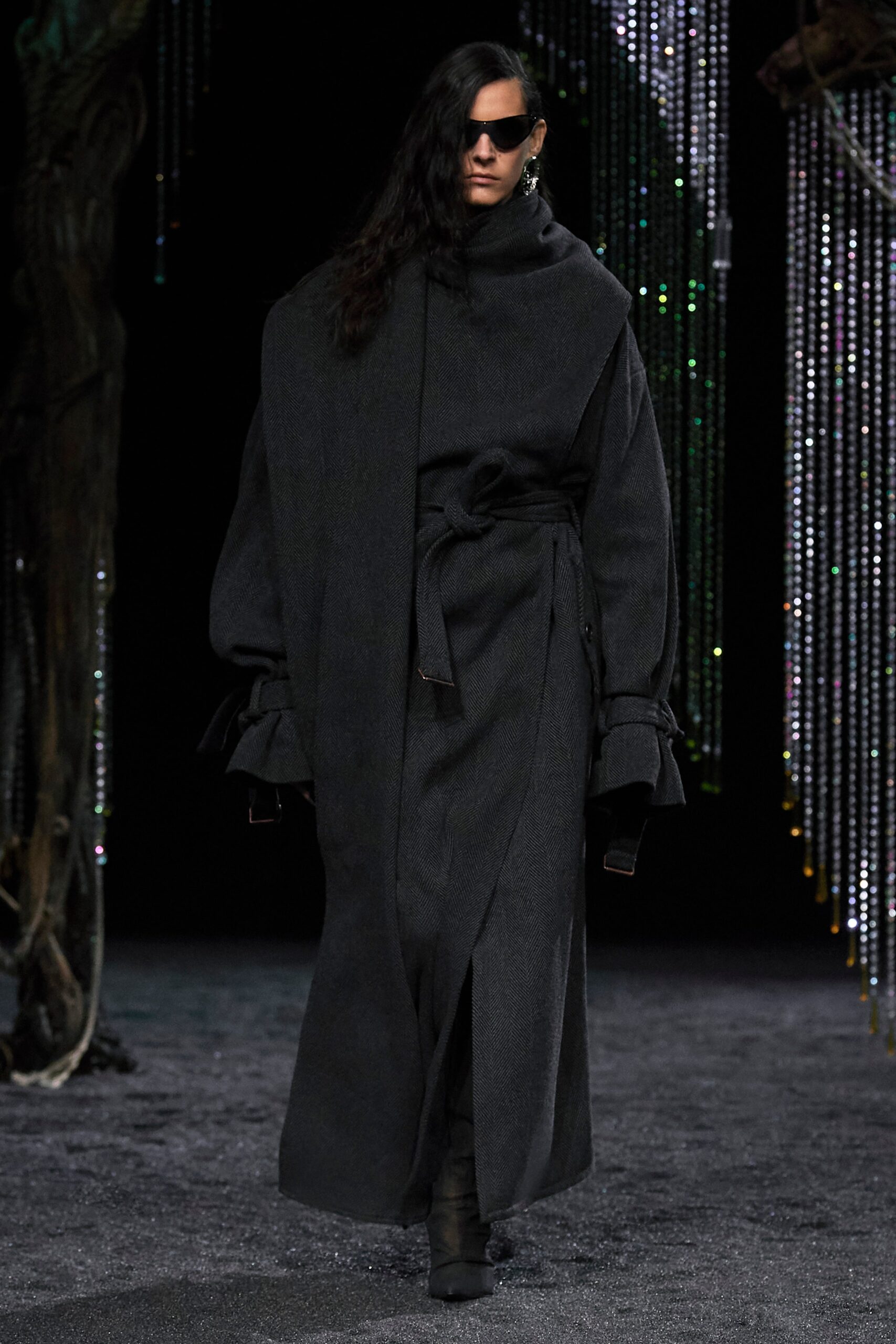 An oversized black wool coat with long sleeves and a belted design.