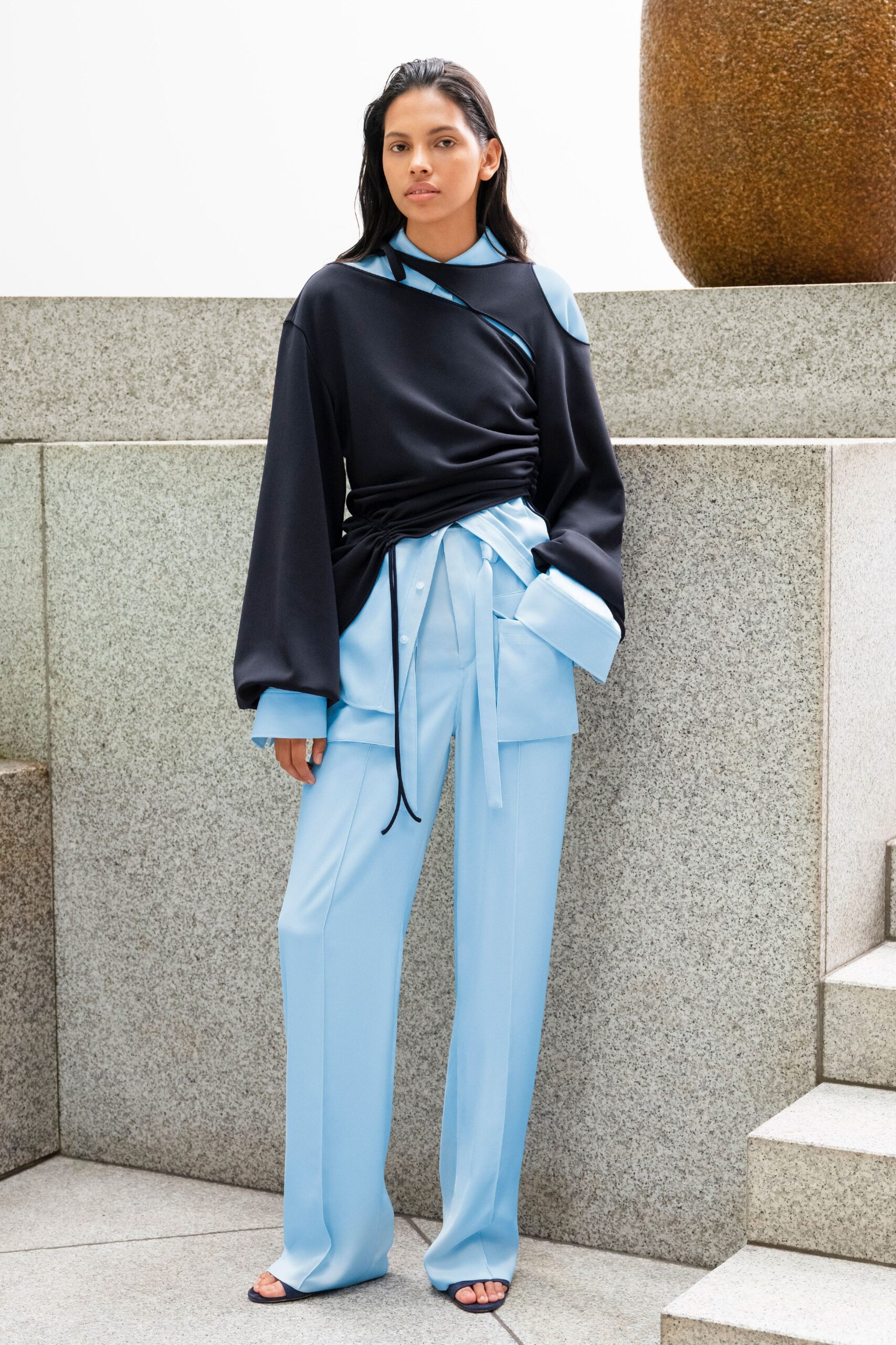 black relaxed top and blue tailored pants
