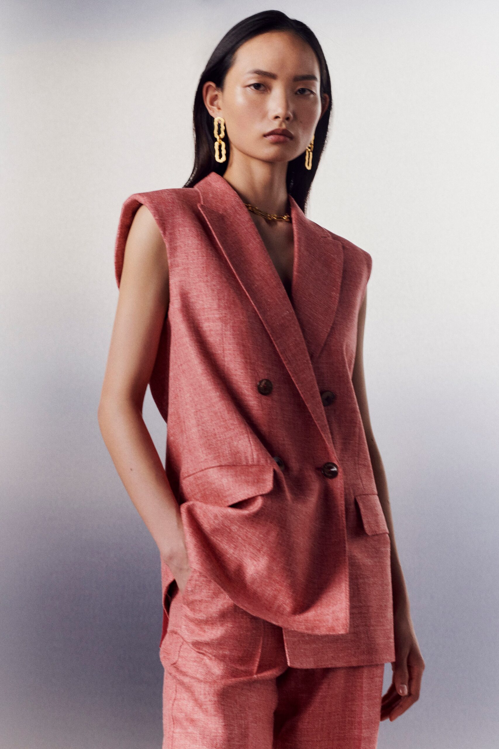 pink sleeveless blazer and tailored pants