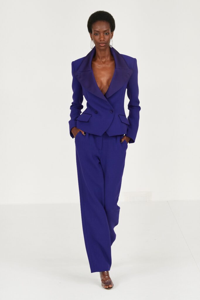 A tailored blue suit featuring a long-sleeve collared jacket and wide-leg trousers.