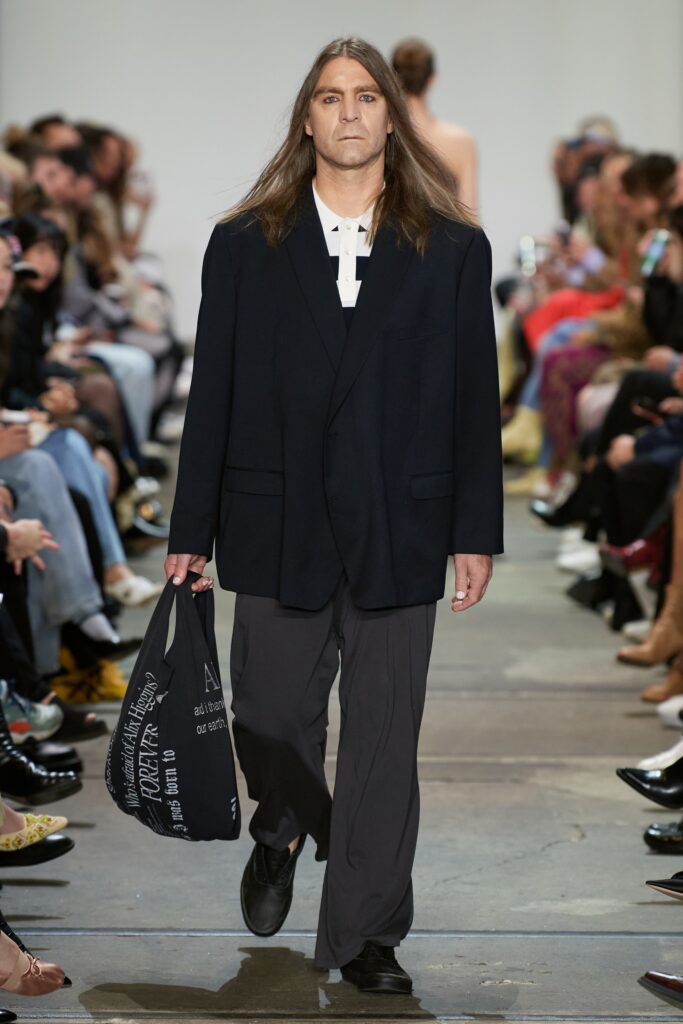 A relaxed black blazer with long sleeves paired with straight-leg pants.