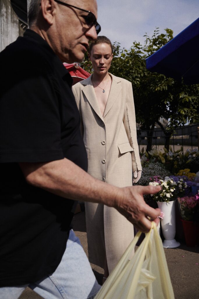 A fitted beige cotton coat with a collared neckline and buttoned details.