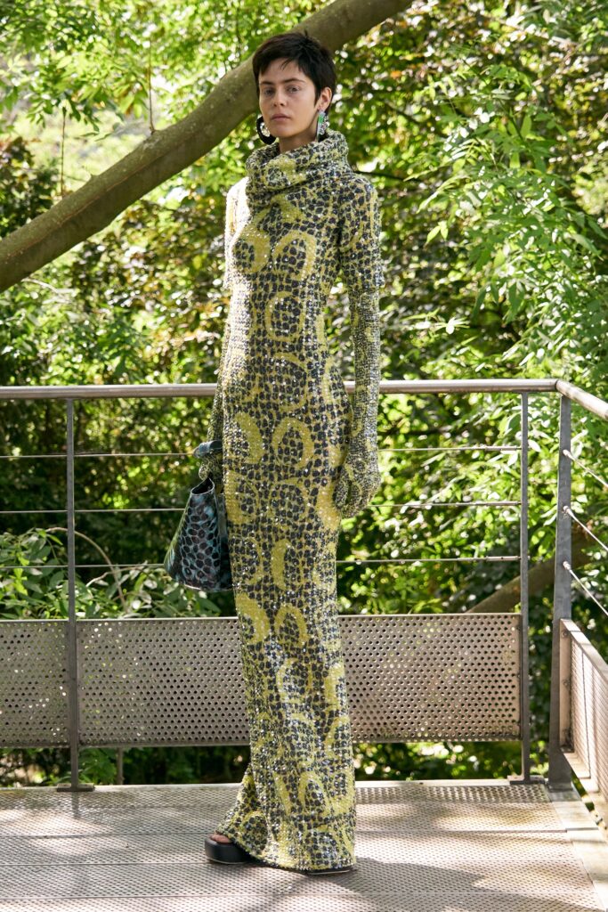 A fitted long-sleeve dress in yellow and green with a high neckline and printed design.