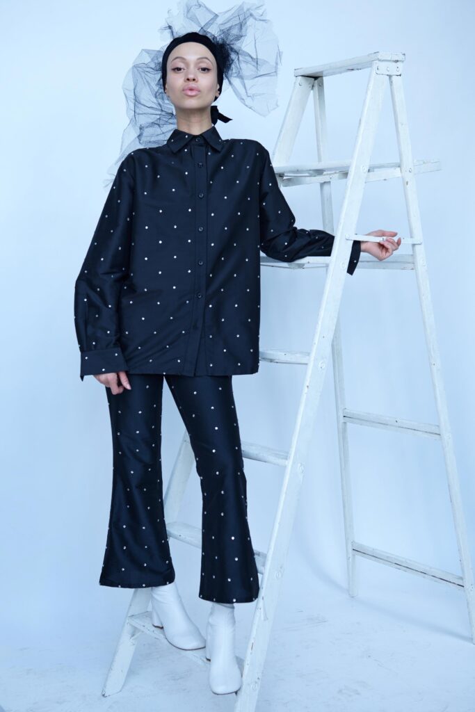 A relaxed black cotton shirt with long sleeves and printed details, paired with matching pants.