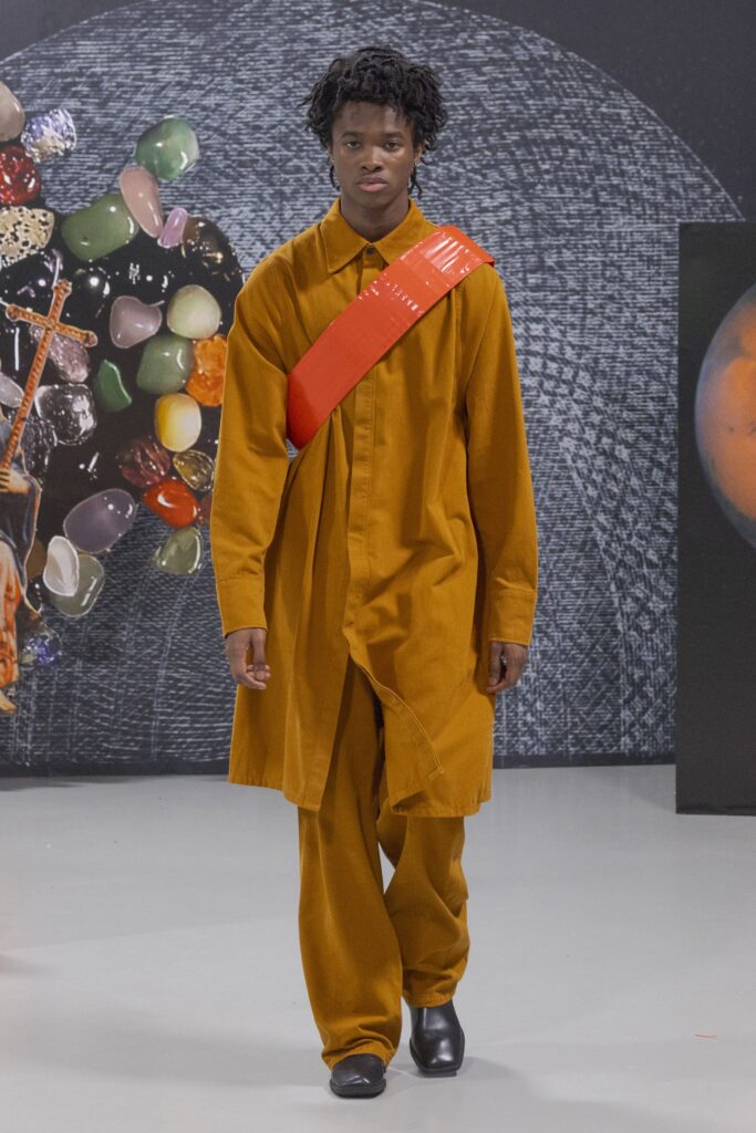 A relaxed orange long-sleeve shirt with a collared design and asymmetric detail, paired with matching pants.