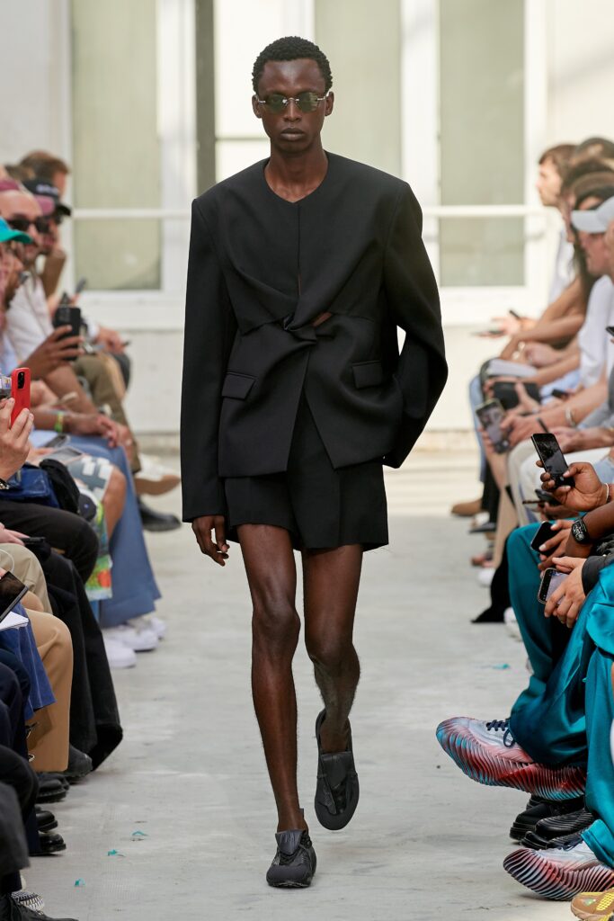 A fitted black blazer paired with matching shorts featuring an asymmetric design.
