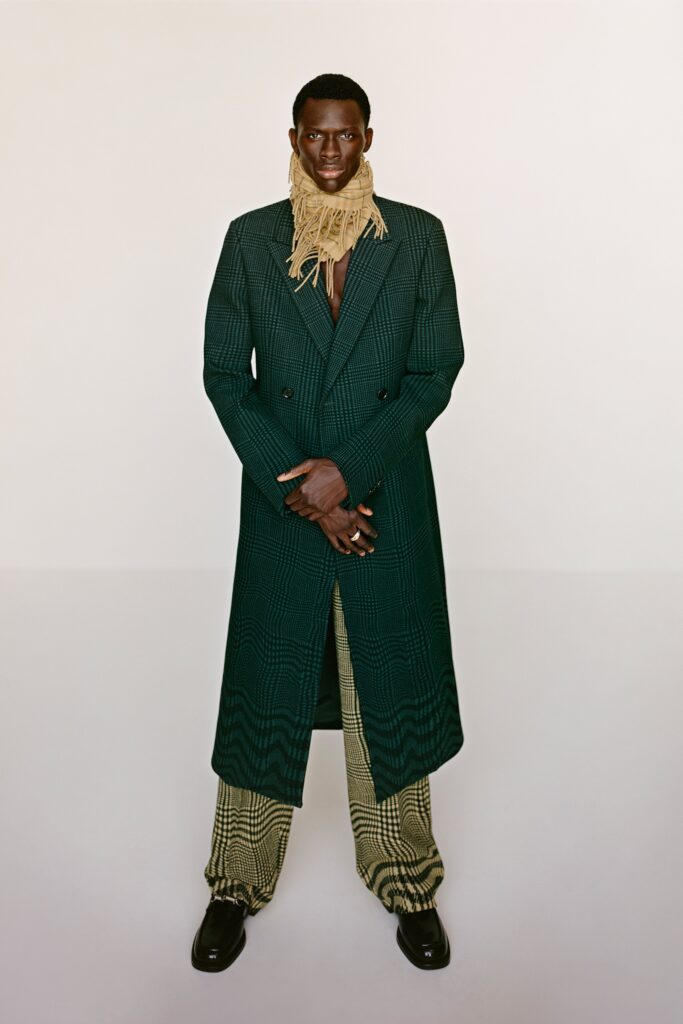 A fitted green checked coat paired with wide-leg beige pants, featuring a collared design.