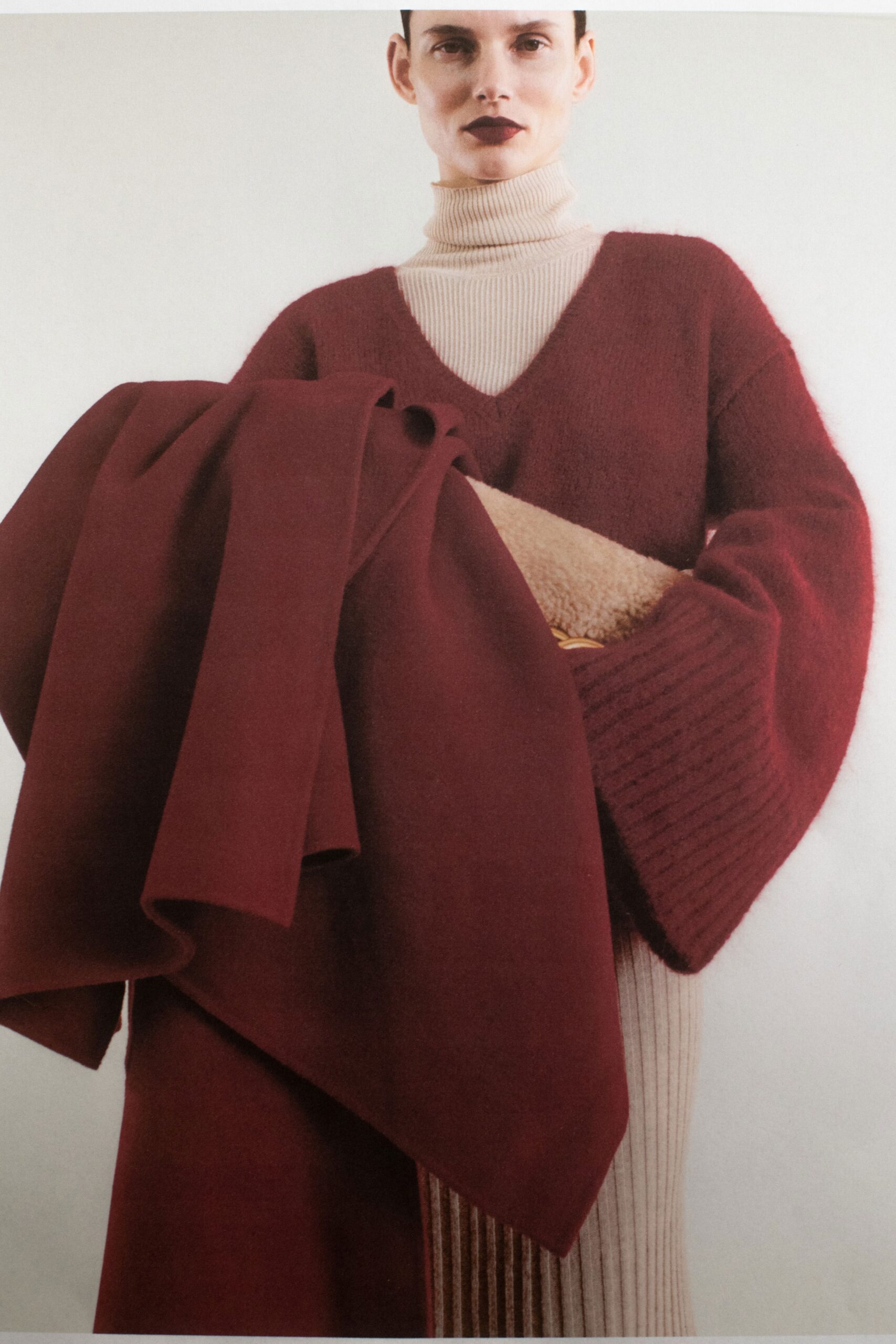 A fitted red wool long-sleeve sweater dress with a V-neckline and layered design.