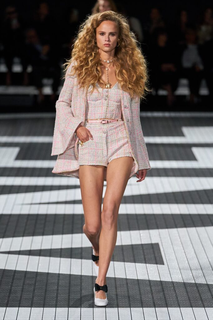 A fitted pink checked jacket with long sleeves paired with matching fitted shorts.