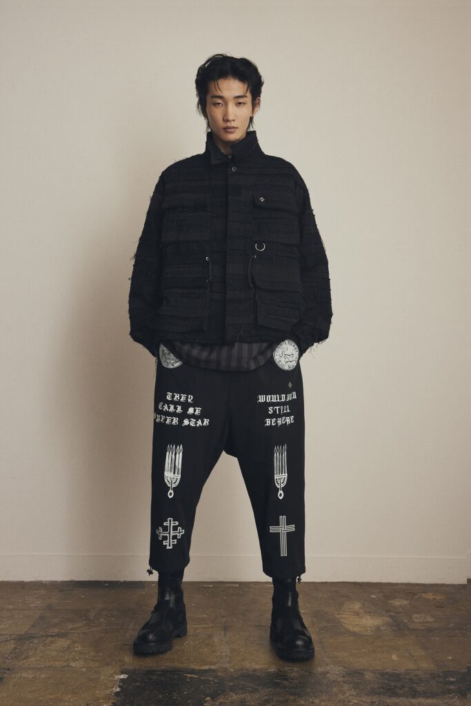 A relaxed black jacket with long sleeves and printed black pants for a contemporary look.