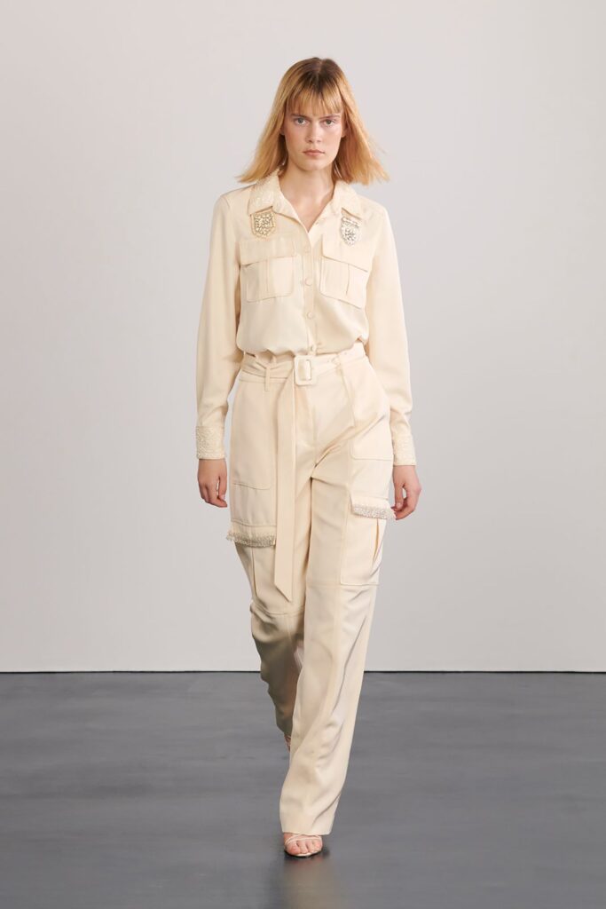 A relaxed beige silk long-sleeve shirt paired with matching pants featuring buttoned details.