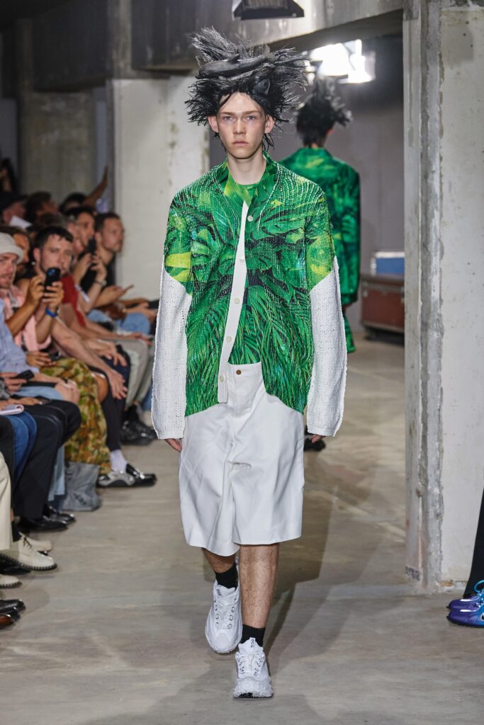 A relaxed fit green printed shirt with long sleeves and white shorts.